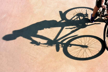 Shadow of the bike and biker on pink surfaceの写真素材