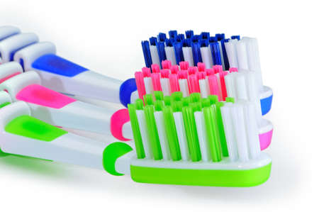 Blue, green, pink toothbrushes isolated on white background.の写真素材