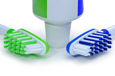Green, blue toothbrushes and toothpaste isolated on a white background.