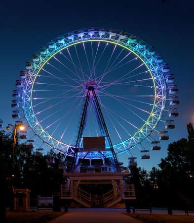 Ferris wheel with multi-colored illumination against the dark blue night sky.の写真素材