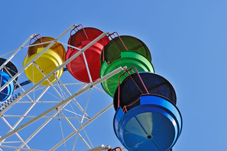 Colorful cabins of ferris wheel against the blue sky.