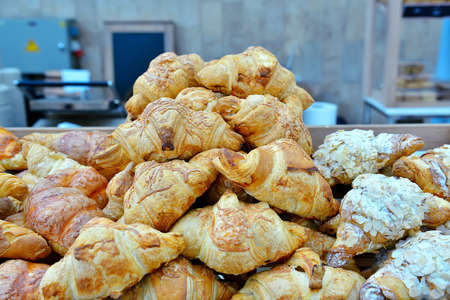 Hill of fresh croissants on the bakery equipment background.の写真素材