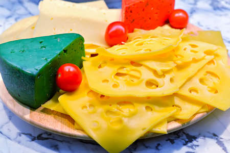 Cheese plate with fresh small red tomatoes.の写真素材