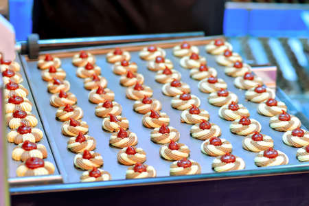 Round cookies with jam on confectionery production.の写真素材