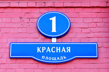 Street signs with an inscription in Russian "Red Square the building number one" in Moscow Russia on a wall from a red brickの写真素材