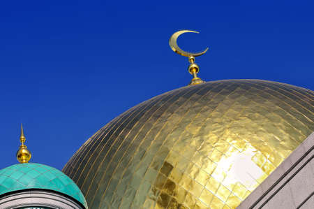 Gilded dome and crescent moon Muslim mosque against the background of the blue skyの写真素材