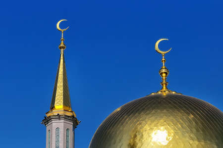 Gilded dome and crescent moon Muslim mosque against the background of the blue skyの写真素材