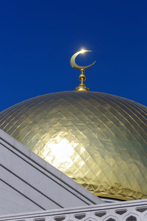 Gilded dome and crescent moon Muslim mosque against the background of the blue skyの写真素材
