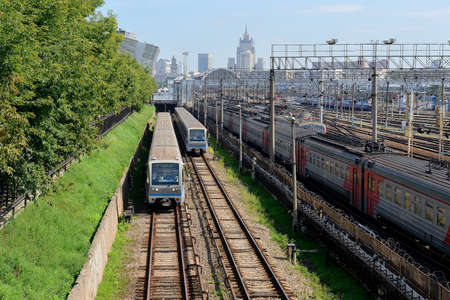 MOSCOW, RUSSIA - AUGUST 24, 2016: Subway trains on the above-ground portion of the Filevskaya subway line. On the right is the local train, railway tracks of the Kievskiy railway stationのeditorial素材