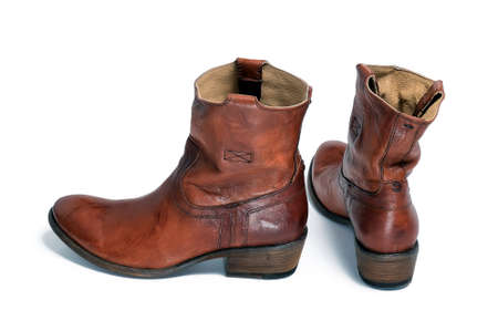 Pair of brown leather cowboy boots are isolated on a white backgroundの写真素材