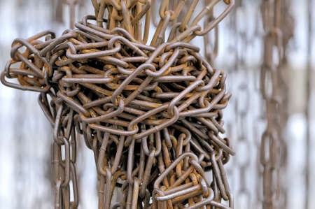 Old rusty metal chains are tied in knot close upの写真素材