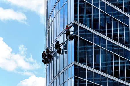 Industrial climbers wash the front windows of a modern skyscraperの写真素材