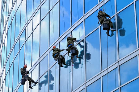 Industrial climbers wash the front windows of a modern skyscraperの写真素材