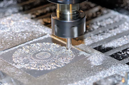 Machining of a metal part on an industrial milling machine. On a surface of a detail there are particles of metal and shavingの写真素材