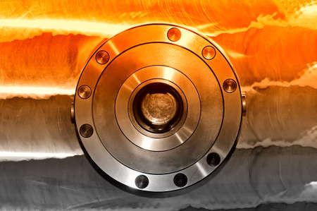 Round industrial metal detail on a metal plate. Front view. Selective red toningの写真素材