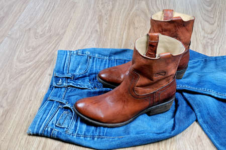 New classical leather brown cowboy boots on blue classical jeansの写真素材