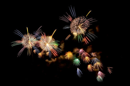 Multicolored flashes of festive fireworks on the night black sky