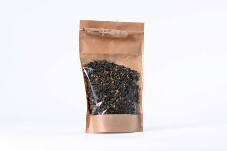 Dry tea leaves of herbal aromatic tea in a gift package with transparent window on a white backgroundの写真素材