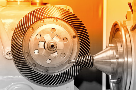 Industrial machine with a conical gear, cogwheel and a circular gear with spiral machine teeth. Red...