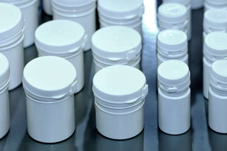 White plastic jars containers of the different sizes for medical tablets and pillsの写真素材