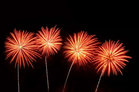 Orange and pink fireworks on dark background.の写真素材