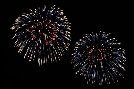 Flashes of red, blue and white fireworks on black background.の写真素材