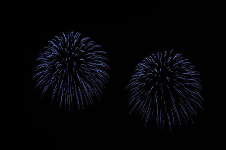 Flashes of fireworks of blue color against the black skyの写真素材