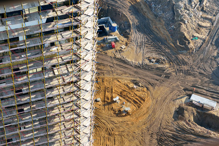 Top view of the construction of a high-rise residential building and a construction site with traces...