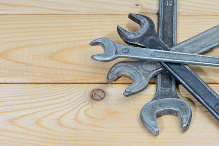 Old used wrenches on a wooden background. Vintage spanners. Close up. Top view. With copy space