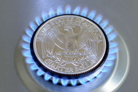 Gas hob with burning natural gas and quarter US dollar coin. The concept of the struggle for global gas markets. Turk stream. North streamの写真素材