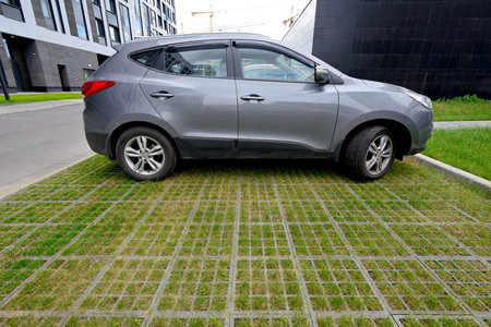 Eco-friendly car parking of concrete cells and turf grass. Car on a modern outdoor parking made from concrete cells and turf grassの写真素材