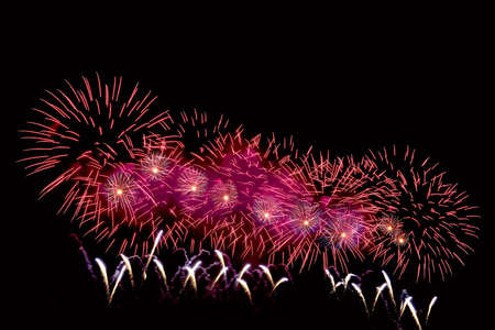 Amazing red fireworks on dark background. Flashes of fireworks of red colorの写真素材