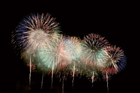 Flashes of colorful fireworks against the background of black skyの写真素材