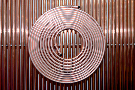 Copper tubes for cooling systems, air conditioners as an industrial background. Copper tubes rolled...