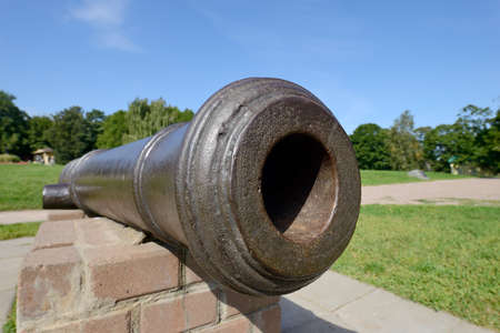 Barrel of an old-fashioned cast-iron cannon. Ancient historical artillery gunの写真素材