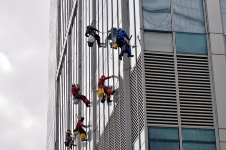 Moscow, Russia - April 29, 2021: Industrial climbers are washing glass on the facade of a skyscraper...