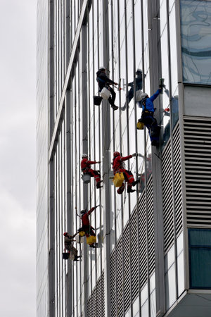 Moscow, Russia - April 29, 2021: Industrial climbers are washing glass on the facade of a skyscraper...