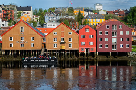 TRONDHEIM, NORWAY - June, 2017. View of  ancient buildings and floating pub on Nidelva river