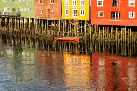 TRONDHEIM, NORWAY - June, 2017. Ancient buildings and canoe on Nidelva river