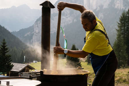 VAL SAN NICOLO', ITALY - August, 2017. Man while mixing polenta at Festa Ta Mont, traditional Ladino festivalのeditorial素材