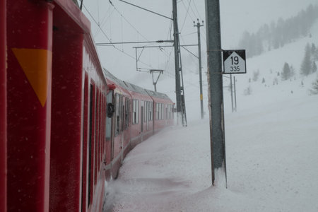 SUROVAS, SWITZERLAND - January, 2018. The train Bernina Express,crosses the Swiss alps in winter with snowのeditorial素材