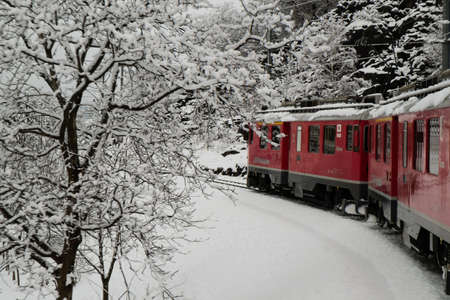 BRUSIO, SWITZERLAND - January, 2018. The train Bernina Express,  crosses the Swiss alps in winter with snowのeditorial素材
