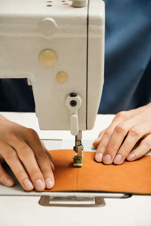 Close up of professional sewing machine for leather work, womans handsの写真素材