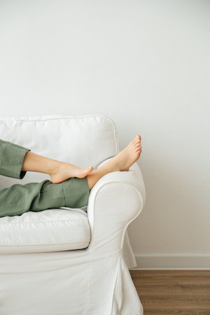 Young woman putting her feet up on sofa