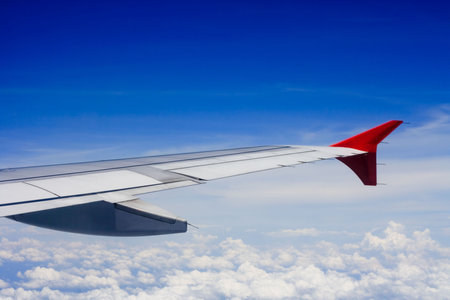 View of wing of plane in the skyの写真素材