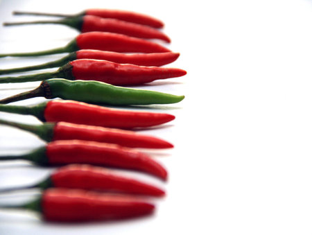 The odd one out, green chili in focus red ones bokeh effect