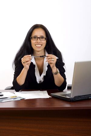attractive businesswoman on her desk holding a penの写真素材