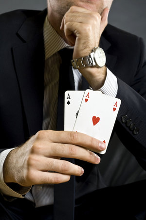 closeup picture of a pair of aces held by a businessman