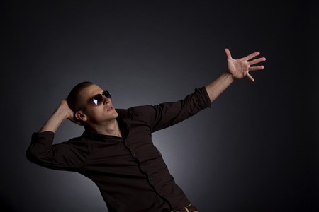 handsome young male model posing over dark backgroundの写真素材