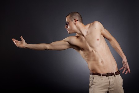 picture of a muscular man with sunglasses reaching outの写真素材